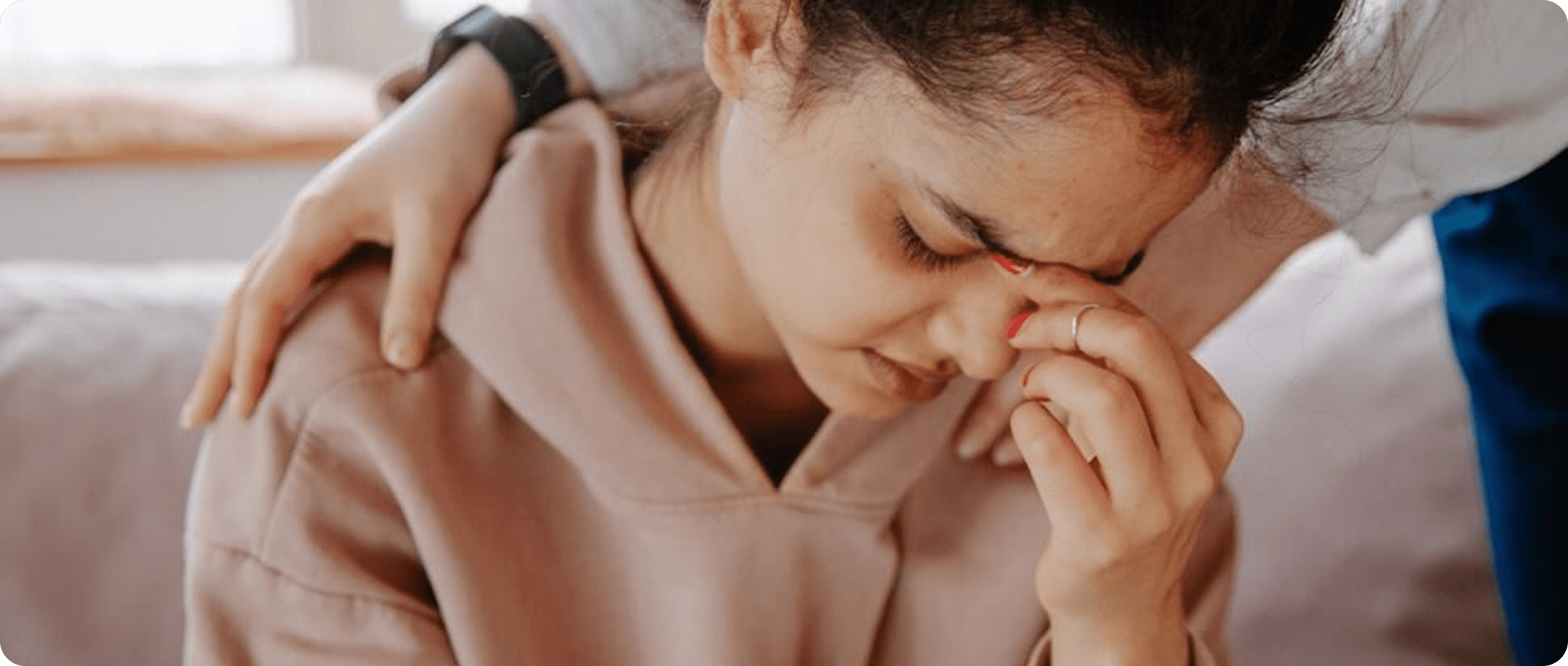 Person comforting a stressed woman
