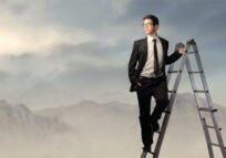 Businessman standing on ladder in suit